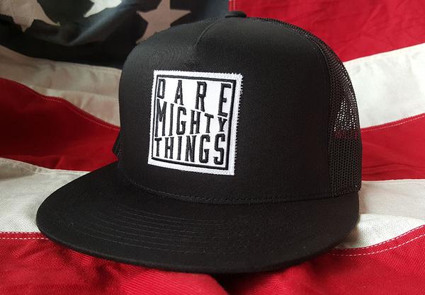 RSVLTS Dare Mighty Things Trucker Hat in Black — front view