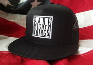 RSVLTS Dare Mighty Things Trucker Hat in Black — front view